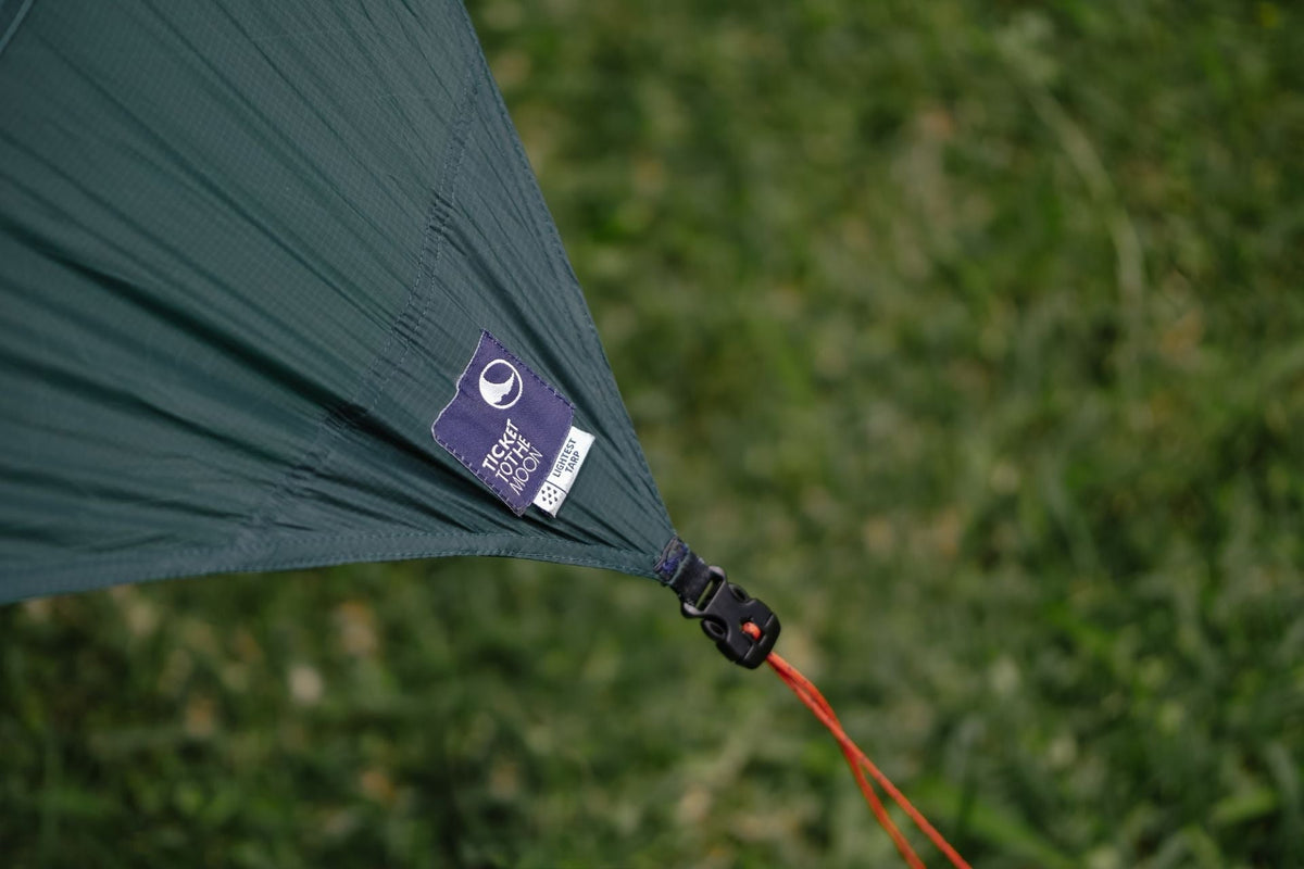 Close-up of a Lightest Tarp corner with its label and orange guyline