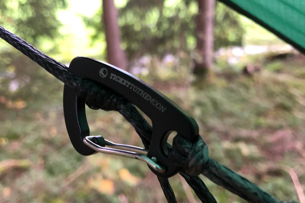 Black Lightest Carabiner 6kN (2-Pack) clipped onto a green guyline in a forest