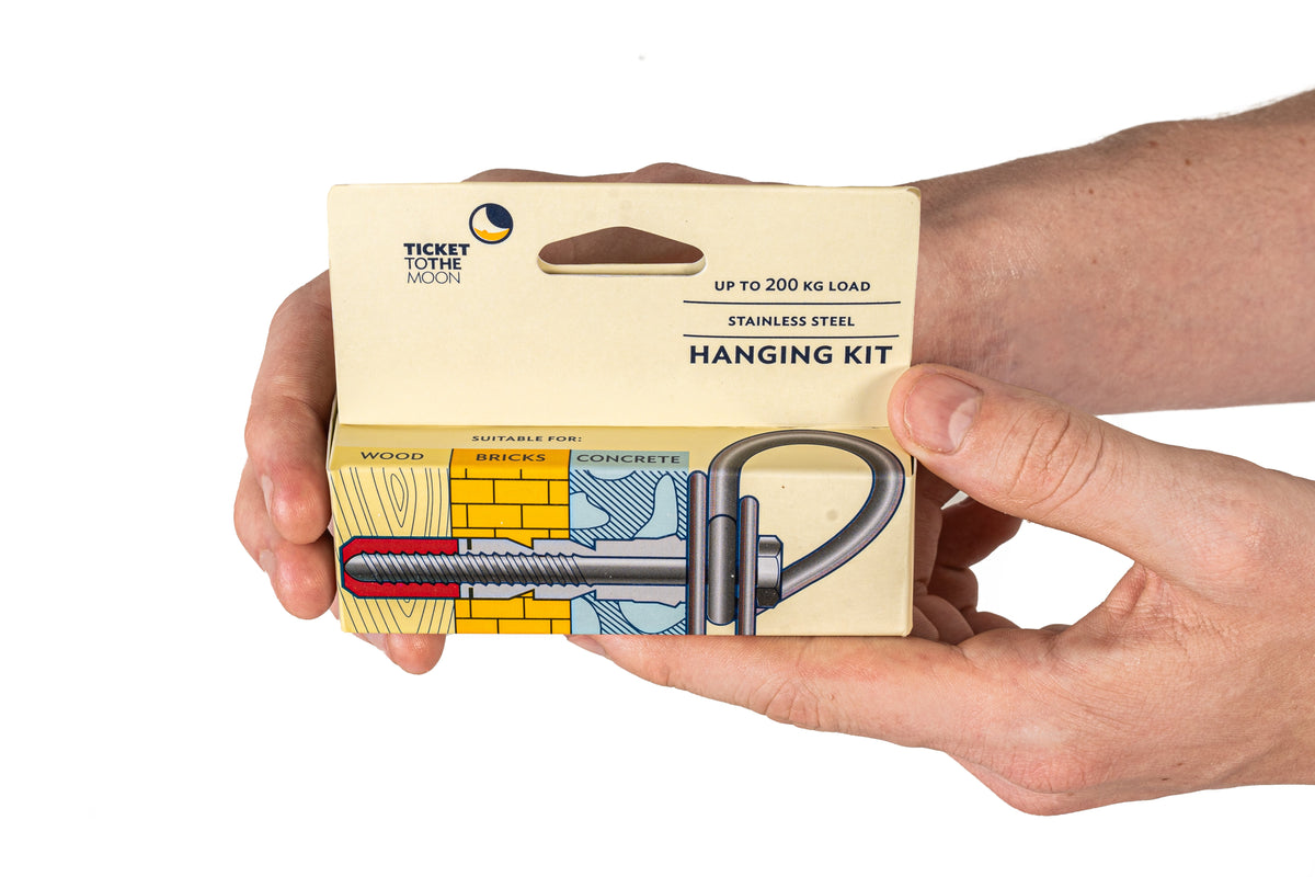 Hands holding the Anchor Kit Set box. Stainless steel hanging kit, up to 200 kg load, suitable for wood, bricks and concrete