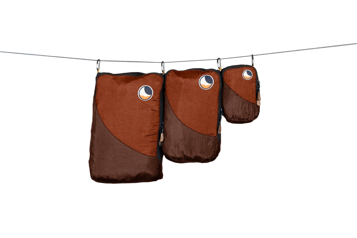 Travel Cube Set in rust brown: large, medium and small packing cubes hanging from a line