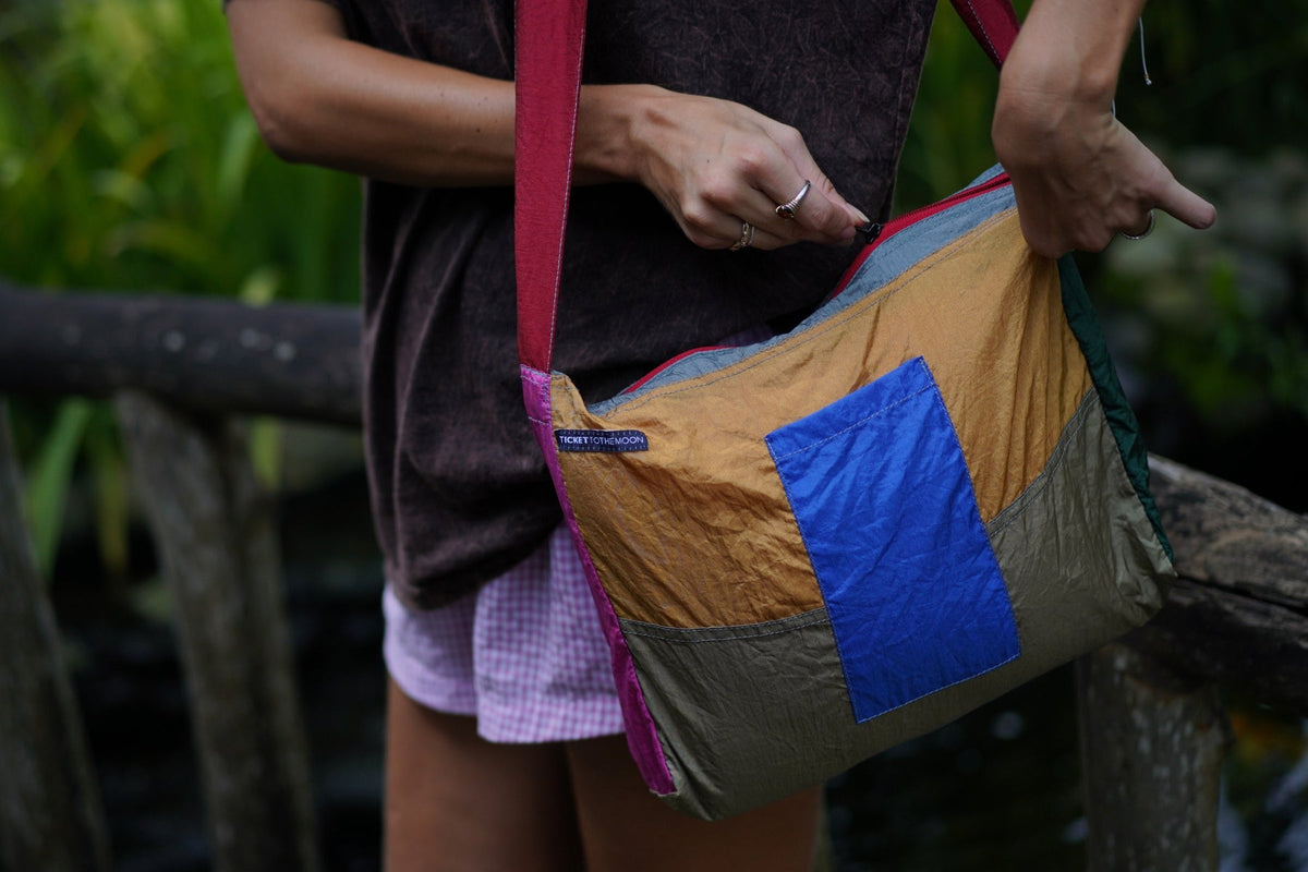 Zipper Bag in yellow, olive and blue patchwork worn on the shoulder with a red strap