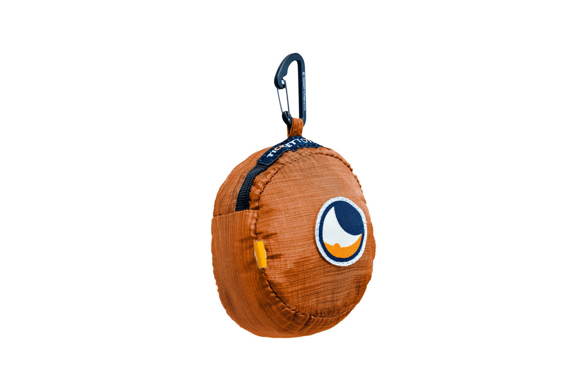 Moon Bag Medium (Premium) folded into its Terracotta Orange pouch with a carabiner