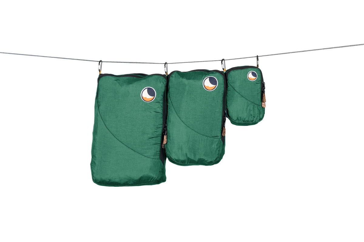 Travel Cube Set in green: small, medium and large packing cubes hanging from a line