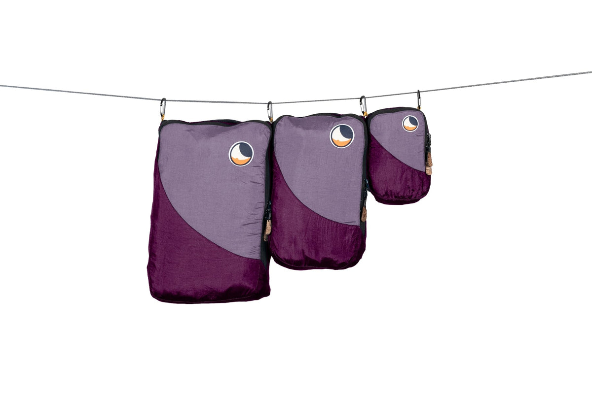 Travel Cube Set in purple and plum: small, medium and large packing cubes hanging from a line
