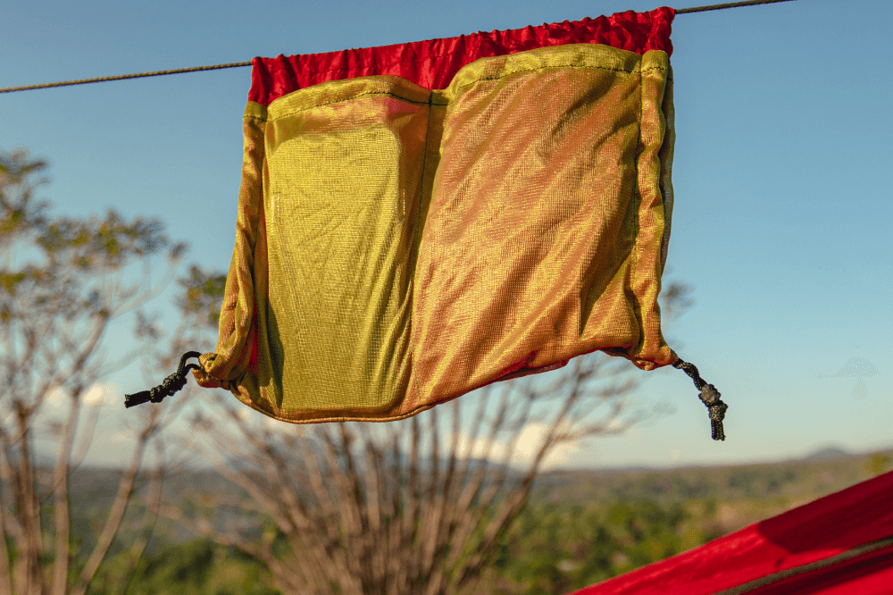 Close-up of the red Pro Hammock (Custom) mesh organiser pouch hanging from the ridgeline in sunshine