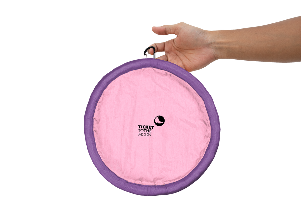 Moon Disc (Pocket) in pink with purple rim, held by its clip in one hand