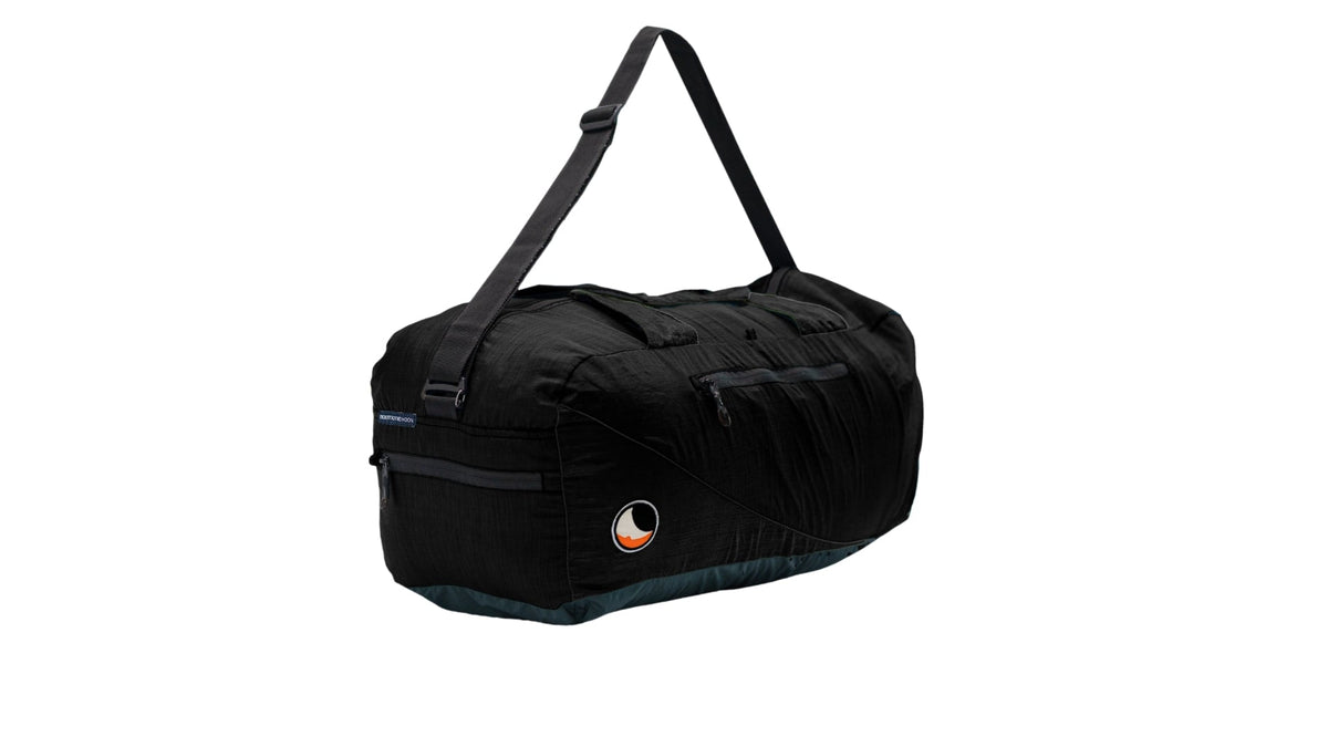 Moon Carrier in black, a duffel bag with black shoulder strap and side zip pockets