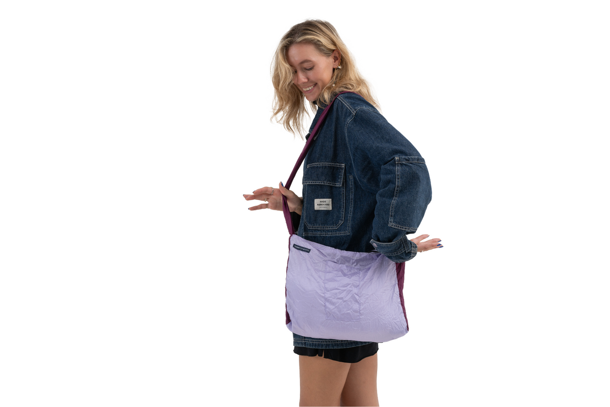 Zipper Bag in Light Purple and Plum, worn crossbody by a smiling woman in a denim jacket