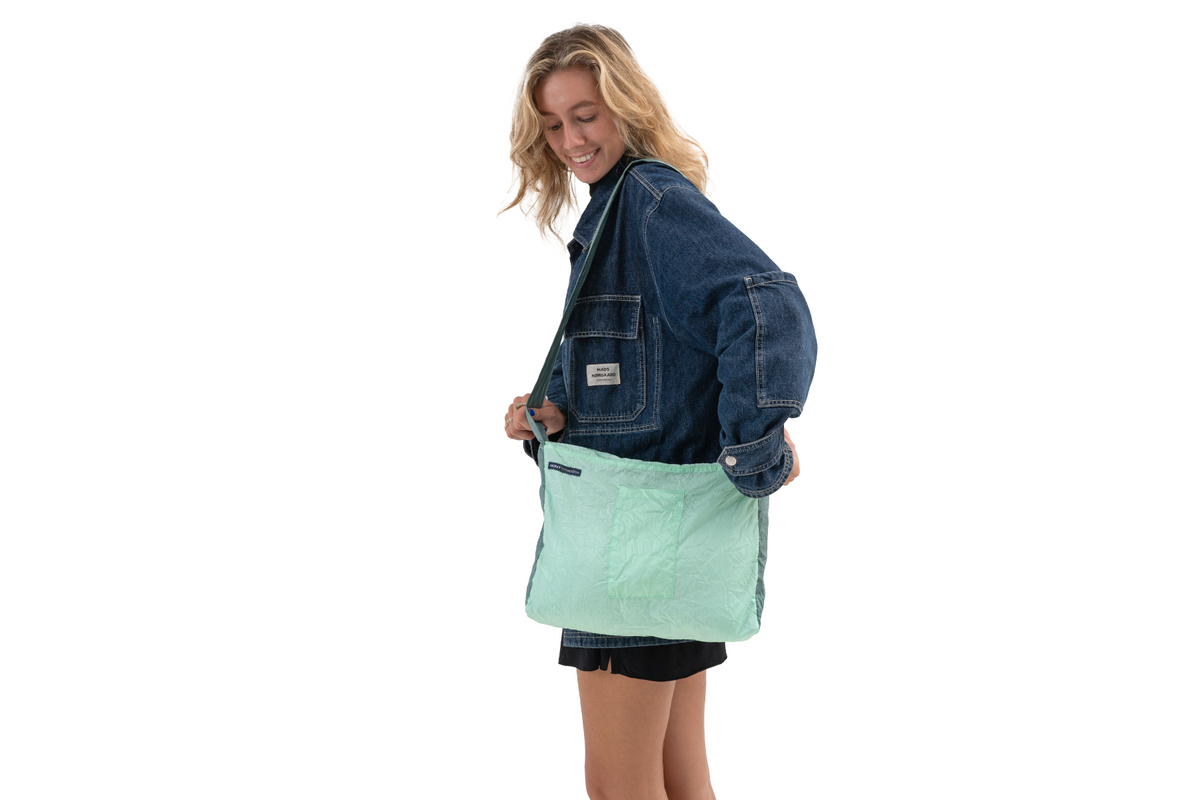 Zipper Bag in Mint and Jade Green carried on the shoulder by a smiling woman in a denim jacket