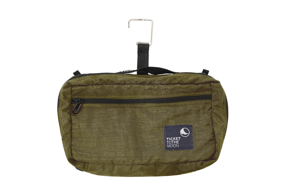 Wash Bag in olive green with front zip pocket, hanging from its metal hook