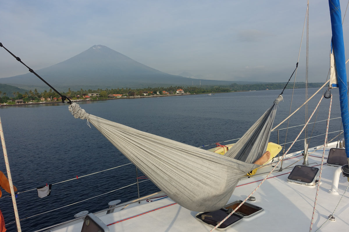 Frosty Grey Home Hammock 320 hung on the deck of a sailboat with a volcano across the bay