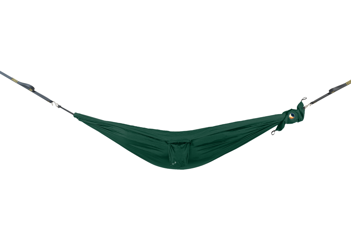 Travel Hammock Mini in dark green hung empty from tree straps, small pocket in the middle
