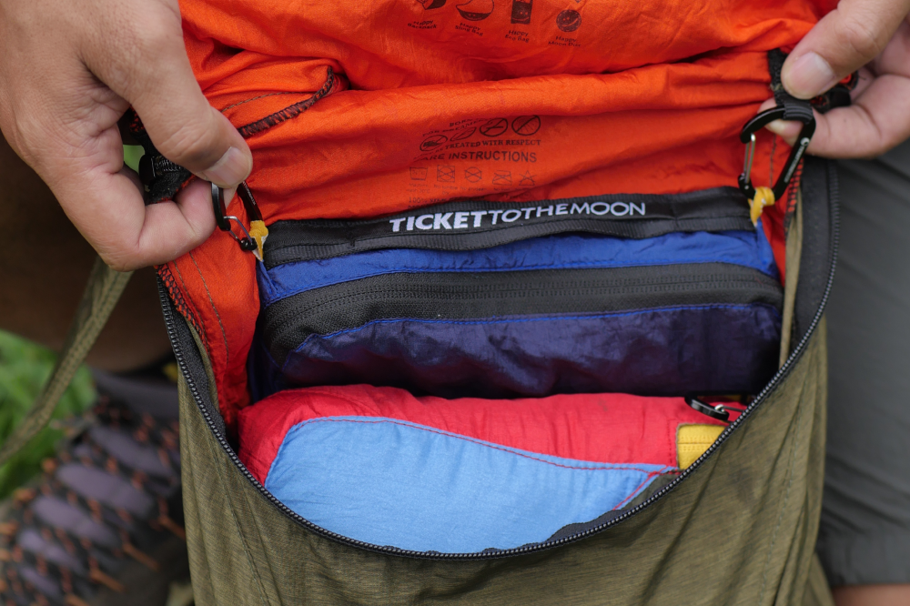 Hands opening a bag to show Travel Cube Large cubes packed neatly inside